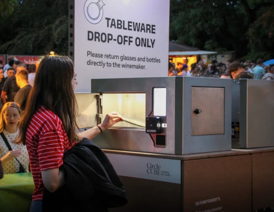 Visitor returning a dish through the hatch of a CircleCube kiosk at the Mainzer Weinmarkt